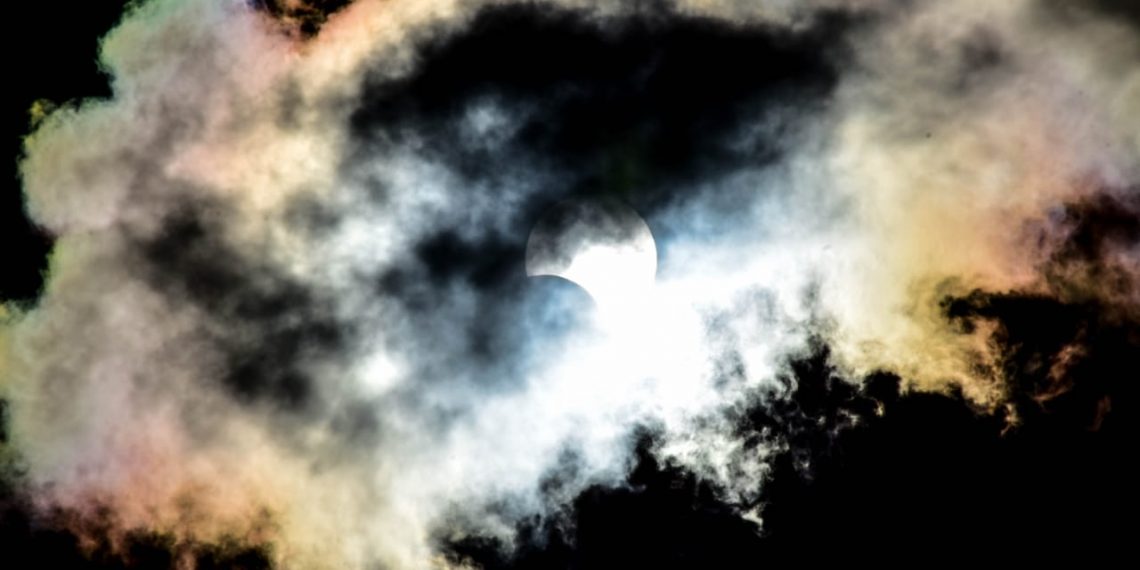 sol parcialmente tapado con nubes